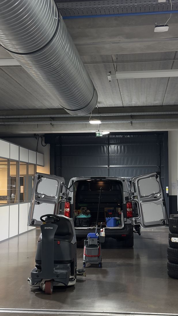 Véhicule d’intervention ouvert, autolaveuse et chariot de lavage dans un atelier